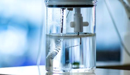 Figure. Water electrolysis in action. The double-bent plate at the center served as the electrode material used for electrocatalyst degradation testing in this research.